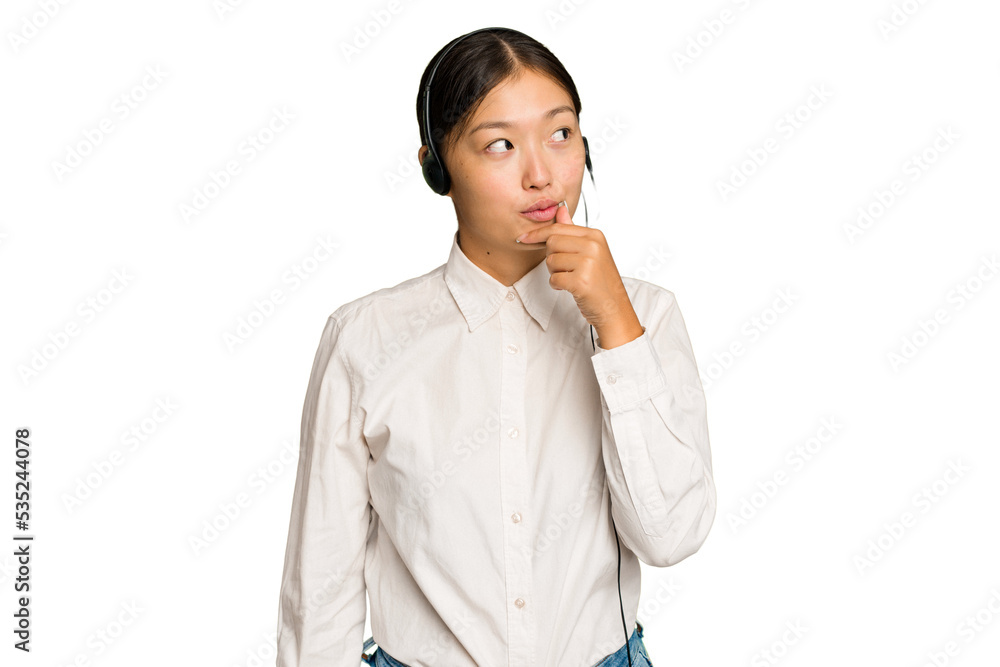Telemarketer asian woman working with a headset isolated on green chroma background looking sideways with doubtful and skeptical expression. Telemarketer asian woman working with a headset isolated on green chroma background looking sideways with doubtful and skeptical expression.