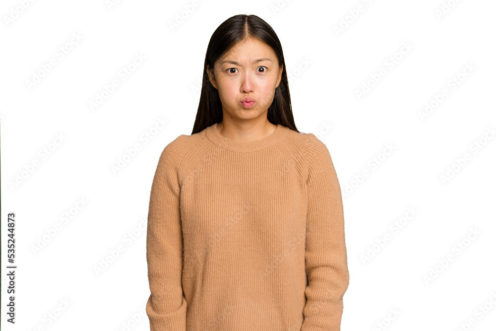 Young Asian woman isolated on green chroma background blows cheeks, has tired expression. Facial expression concept. Young Asian woman isolated on green chroma background blows cheeks, has tired expression. Facial expression concept.