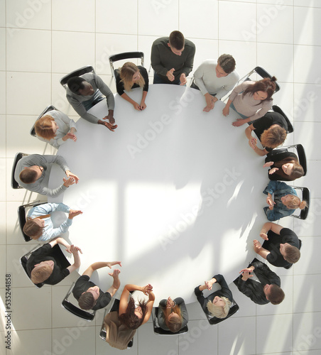 Fotografía top view. young people shaking hands at a round table meeting