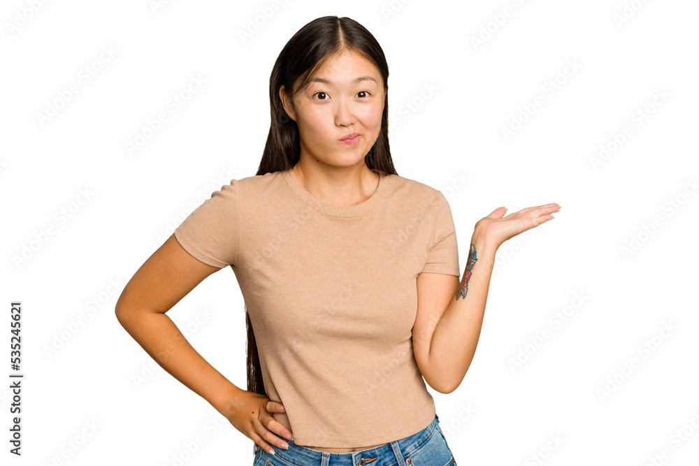 Young Asian woman isolated on green chroma background showing a copy space on a palm and holding another hand on waist. Young Asian woman isolated on green chroma background showing a copy space on a palm and holding another hand on waist.