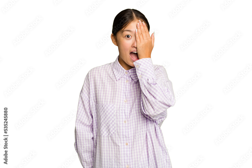 Young Asian woman isolated on green chroma background having fun covering half of face with palm. Young Asian woman isolated on green chroma background having fun covering half of face with palm.