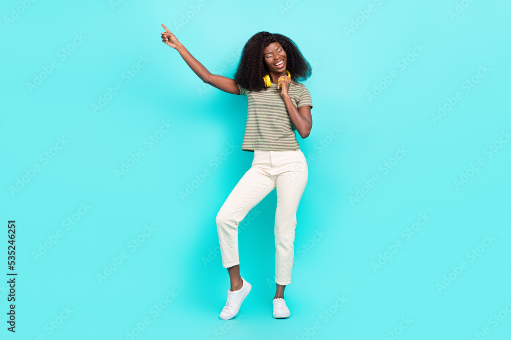 Full length photo of overjoyed satisfied person point finger dancing good mood isolated on emerald color background
