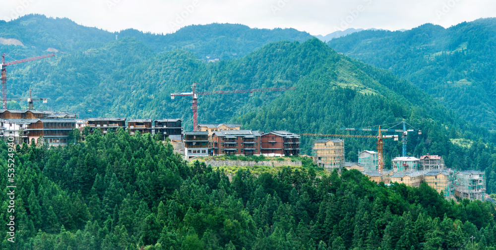 Naklejka premium Construction site with crane on mountain range