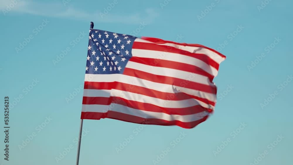 Bright flag of the United States of America against the blue sky Bright flag of the United States of America against the blue sky