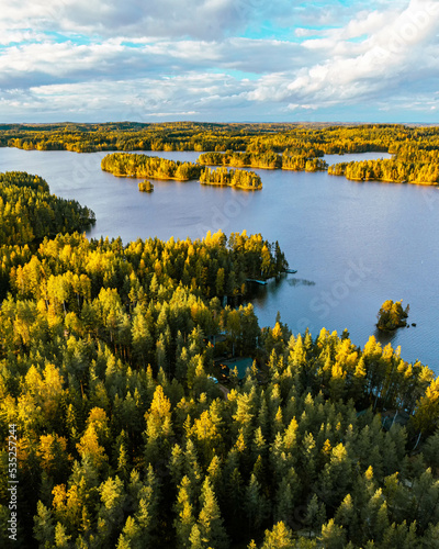 Autumn foliage colored trees, lake house and islands in Heinola, Finland