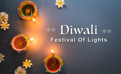 Happy Diwali - Clay Diya lamps lit during Diwali, Hindu festival of lights celebration. Colorful traditional oil lamp diya on blue background