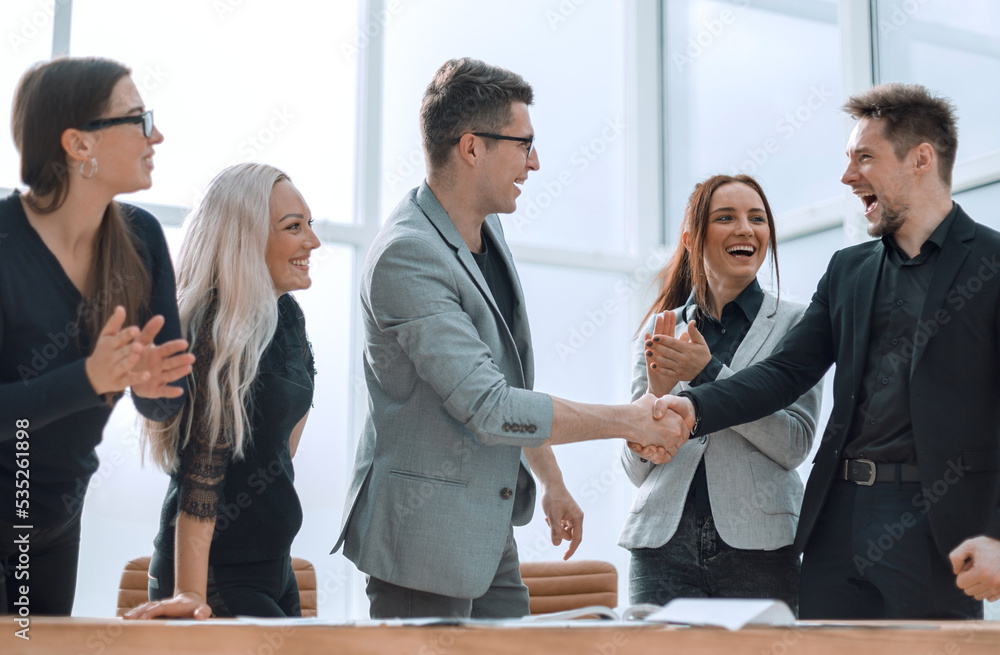 close up. happy employees applaud and shake hands close up. happy employees applaud and shake hands
