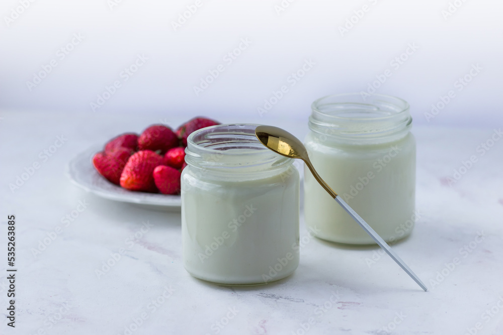 Healthy food at home. Homemade yogurt with strawberries in glass jars Healthy food at home. Homemade yogurt with strawberries in glass jars