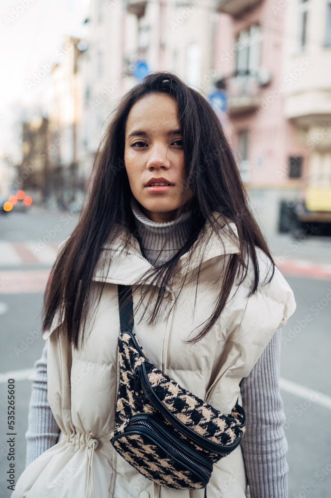 Portrait of a beautiful woman in casual clothes standing in the evening on the street and posing for the camera. Portrait of a beautiful woman in casual clothes standing in the evening on the street and posing for the camera.