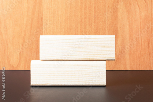 Two wooden blocks with a place to insert text on a light wooden background