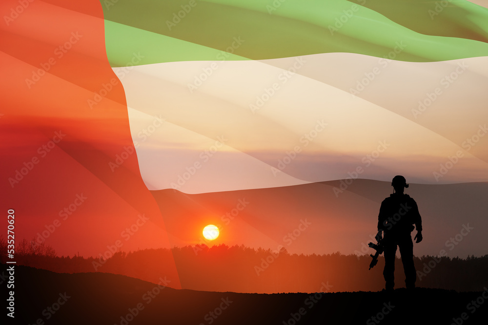 Silhouette of soldier on background of UAE flag and the sunset or the sunrise. Concept of national holidays. Commemoration Day.