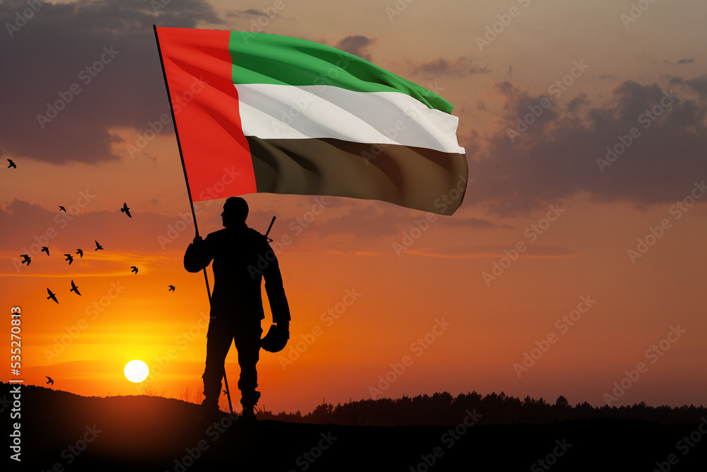 Silhouette of soldier with the flag of UAE against sunset or sunrise. Concept of national holidays. Commemoration Day.