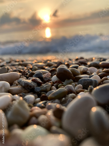 View of the sea and sun rising above the stones in Cirali  Antalya  Turkey. Selective focus.