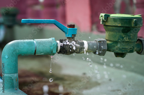 Konstfotografi Water leaks water drop from a long-used blue plumbing pipe