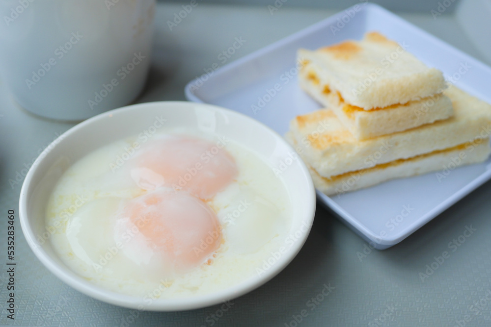 half boiled egg, toasted bread and tea on table half boiled egg, toasted bread and tea on table