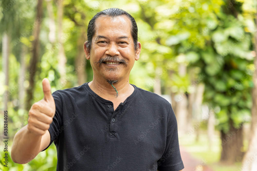 Happy smiling middle aged man showing thumb up gesture Happy smiling middle aged man showing thumb up gesture