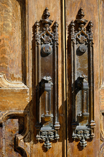 Ancient Antique Door Handles on Old Worn Wooden Doors