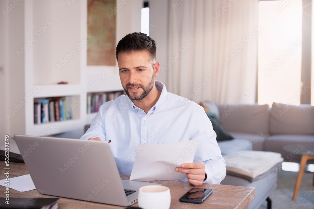 Casual man using laptop while working at home Casual man using laptop while working at home