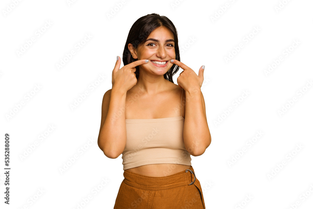 Young Indian woman isolated on green chroma background smiles, pointing fingers at mouth. Young Indian woman isolated on green chroma background smiles, pointing fingers at mouth.
