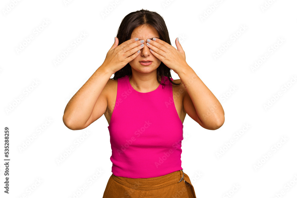 Young Indian woman isolated on green chroma background afraid covering eyes with hands.