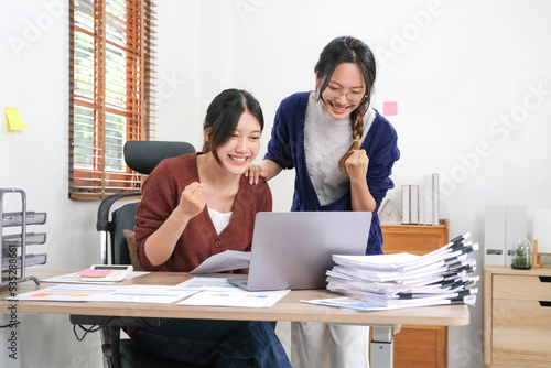 Two asian woman celebrating victory, won profitable contract, unexpected amazing win, big deal on stock, impressive achievement, unbelievable success, funny positive emotions at home