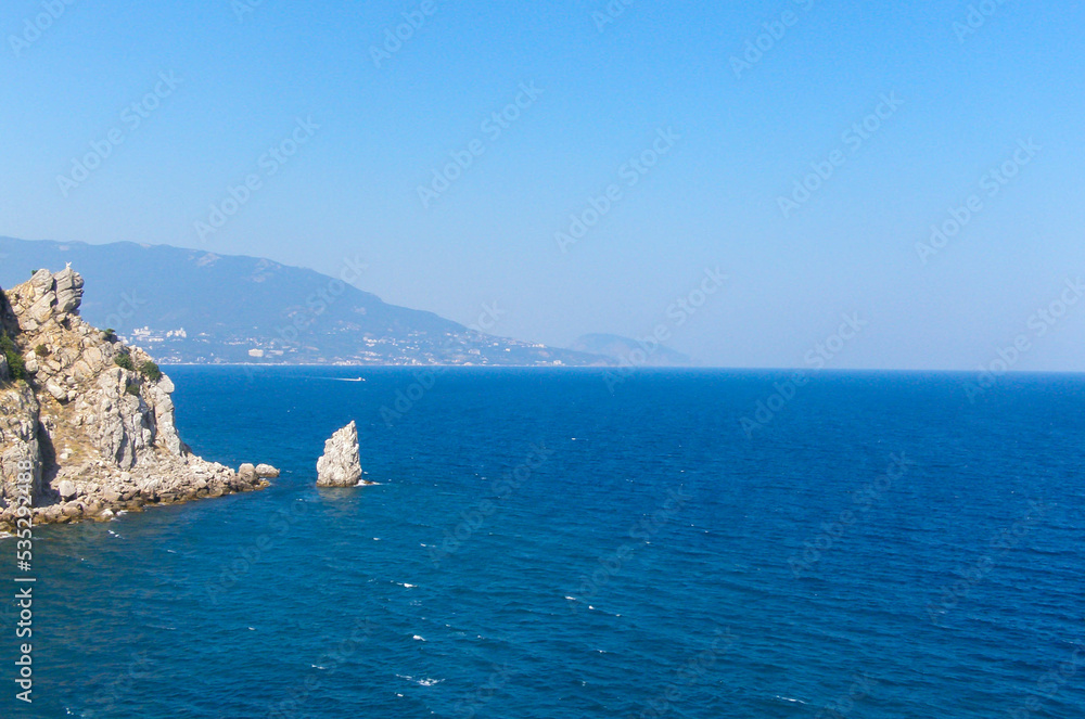 The sea is blue to the horizon during the summer day