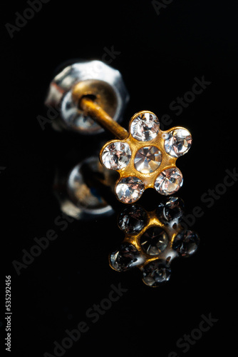 Jewelry with stones earrings, luxury golden earrings with diamonds, jewels on a black background.