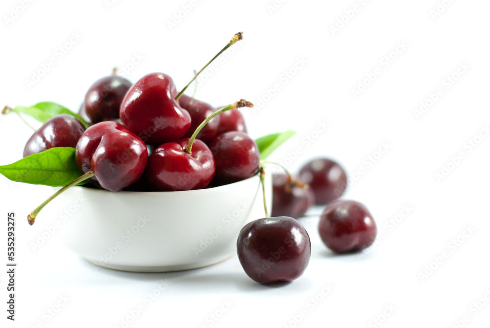 Cherries are placed in a white ceramic cup. and put on a white background. Cherries are placed in a white ceramic cup. and put on a white background.