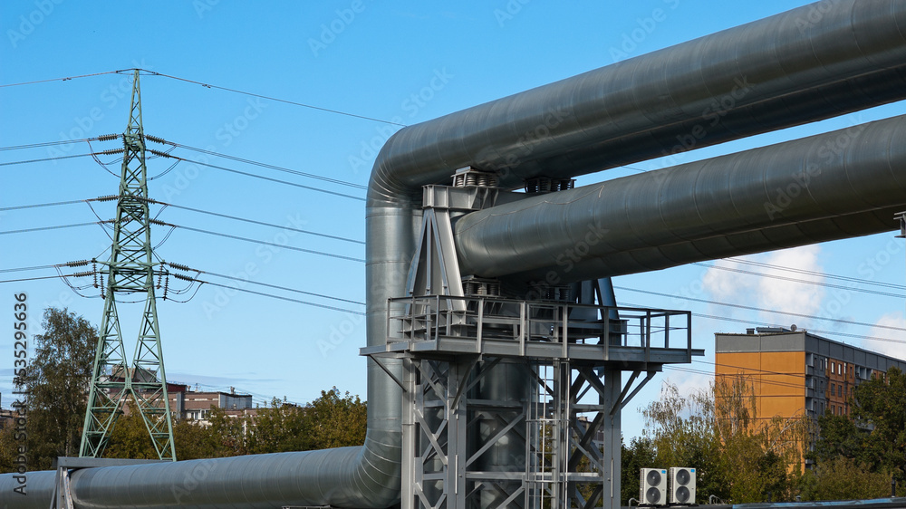 pipeline and power lines, in the photo pipelines and power line support on the background of the blue sky of the buildings of the city pipeline and power lines, in the photo pipelines and power line support on the background of the blue sky of the buildings of the city