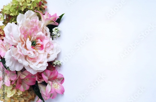 Bouquet of pink roses, peonies and alstroemeria on a white background. Festive flower arrangement. Background for a greeting card. © Olirina
