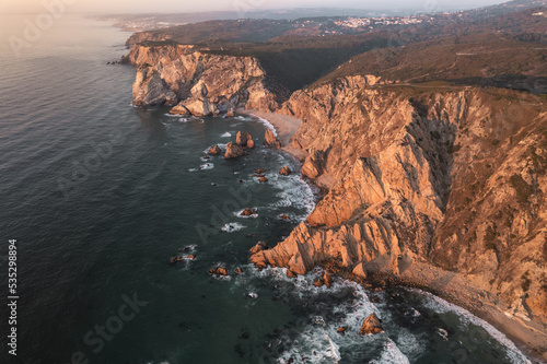 Scenic seascape with sandy coast surrounded by massive rocky cliffs