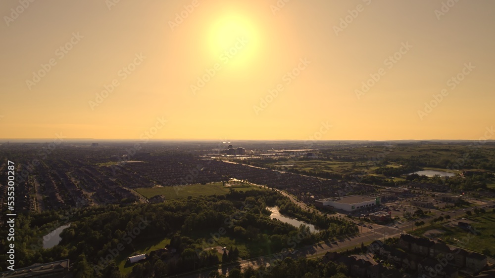 Aerial view of American suburban neighbourhood. Residential single American family houses. North America suburb streets. Established Real estate at golden hour sunset with long shadows.