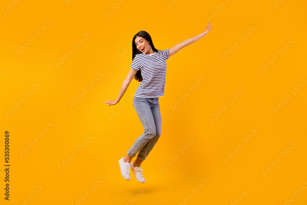 Full body portrait of cheerful pretty person jumping have good mood isolated on yellow color background