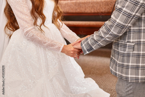 During the wedding ceremony, the bride and groom hold hands. Wedding celebration.