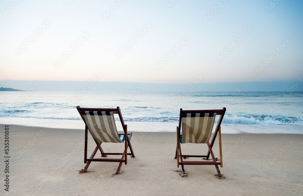 Two chairs on the beach.