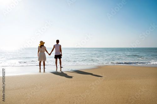 Young couple holding hand at the beach.