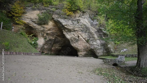 Gutman's cave in red sandstone rock in Sigulda in autumn. A small cave with inscriptions from the 17th century is a favorite place for tourists to visit. Gauja National Park in Latvia photo