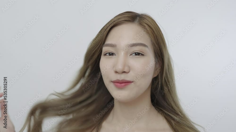Beautiful Asian woman, natural cosmetic skincare products look at camera, smiling, touching face and healthy skin in slow motion, wellness. Beauty portrait. Beautiful Asian woman, natural cosmetic skincare products look at camera, smiling, touching face and healthy skin in slow motion, wellness. Beauty portrait.
