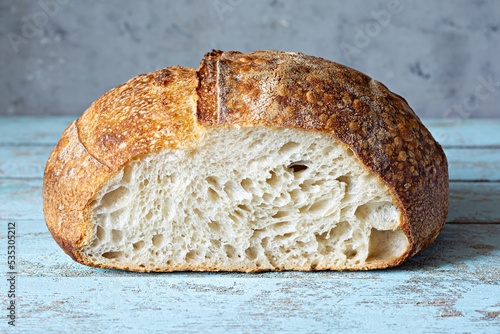 Fotografie Fresh homemade sourdough bread with whole grain flour on a gray-blue background