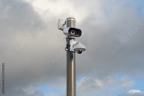 modern surveillance camera in the city. against a cloudy sky