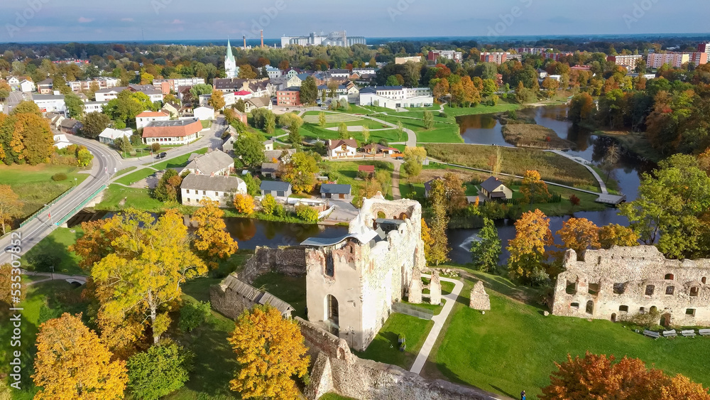 Ruins of an Ancient Medieval Castle Dobele Latvia, Aerial Top View. Aerial Panorama of Dobele City, in the Foreground River With Fontains and Medieval Castle Ruins With Restored Castle Capella, Latvia