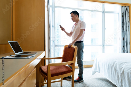 Man using cellphone in bedroom