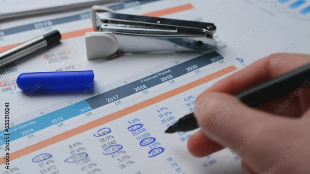 Close-up shot of a chartered accountant checking company balance sheet Close-up shot of a chartered accountant checking company balance sheet