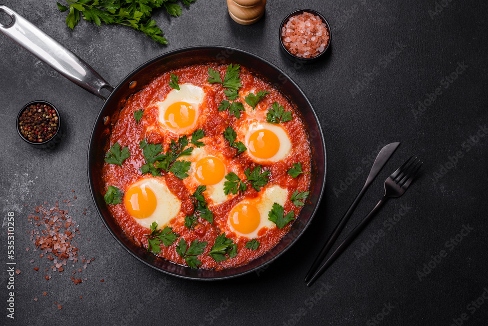 Shakshuka, a dish with fried eggs with tomato sauce, sweet pepper, garlic, onions, spices and herbs Shakshuka, a dish with fried eggs with tomato sauce, sweet pepper, garlic, onions, spices and herbs