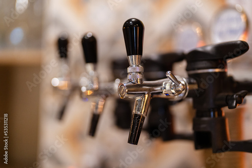 Beer taps in a row in perspective. Close up of beer Tap. Selective focus. Details of the beer bar.