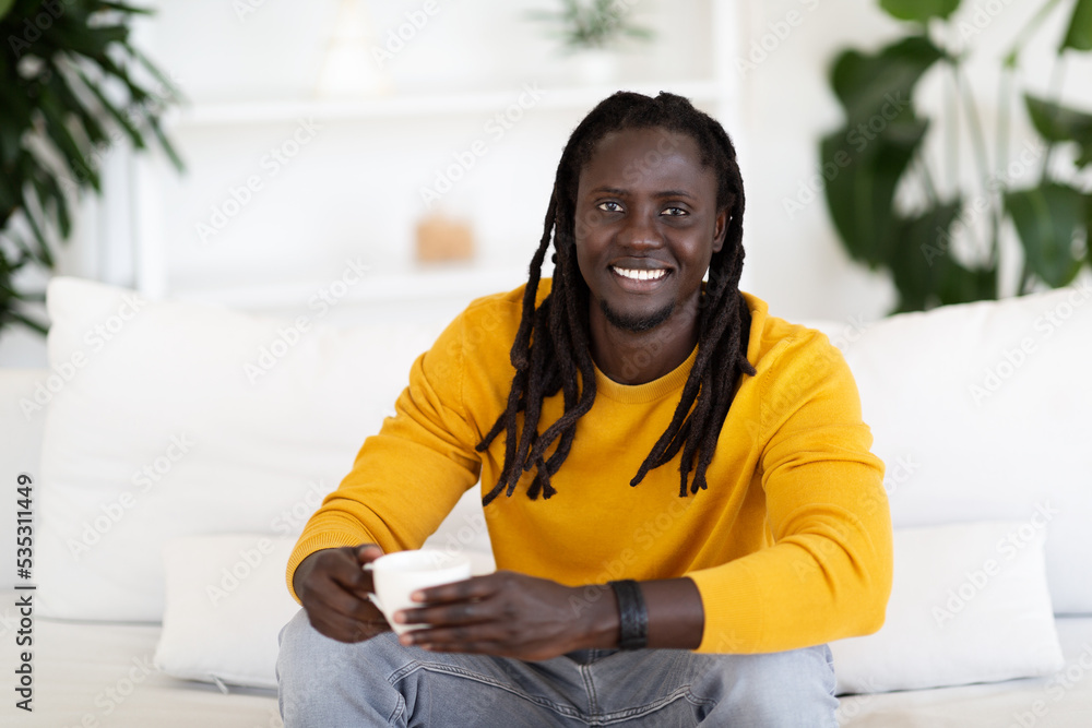 Handsome Young Black Man Drinking Coffee While Relaxing On Couch At Home Handsome Young Black Man Drinking Coffee While Relaxing On Couch At Home