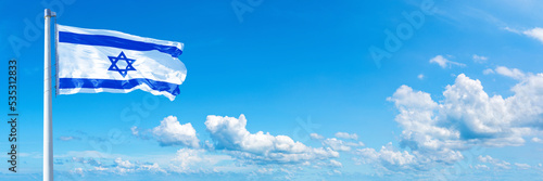 Israel flag waving on a blue sky in beautiful clouds - Horizontal banner