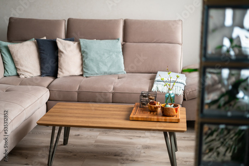 Bright living room interior Comfortable couch with decorative pillows natural colors. Wooden details