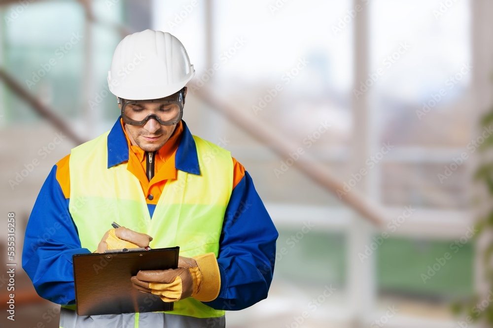 Portrait man worker supervisor with engineer safety suit work in large factory warehouse Portrait man worker supervisor with engineer safety suit work in large factory warehouse