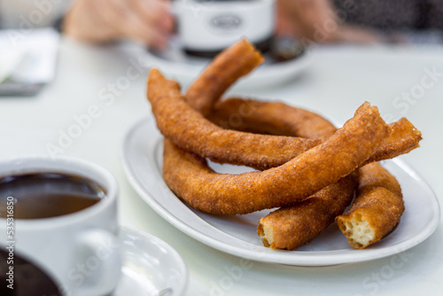 Baked churros ready to eat, on a white tray photo